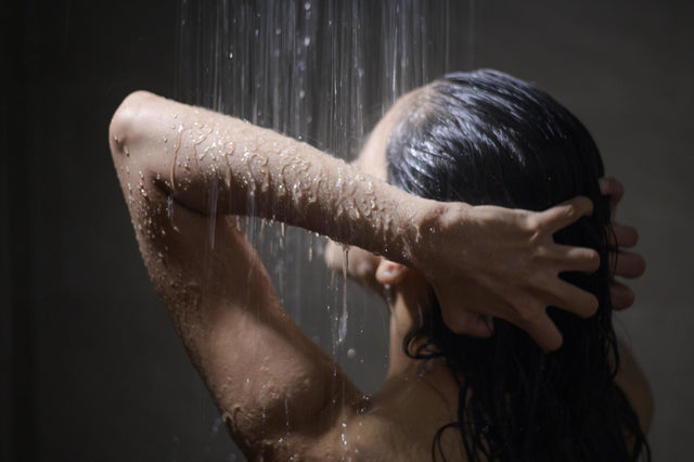 Mujer tomando una ducha fría