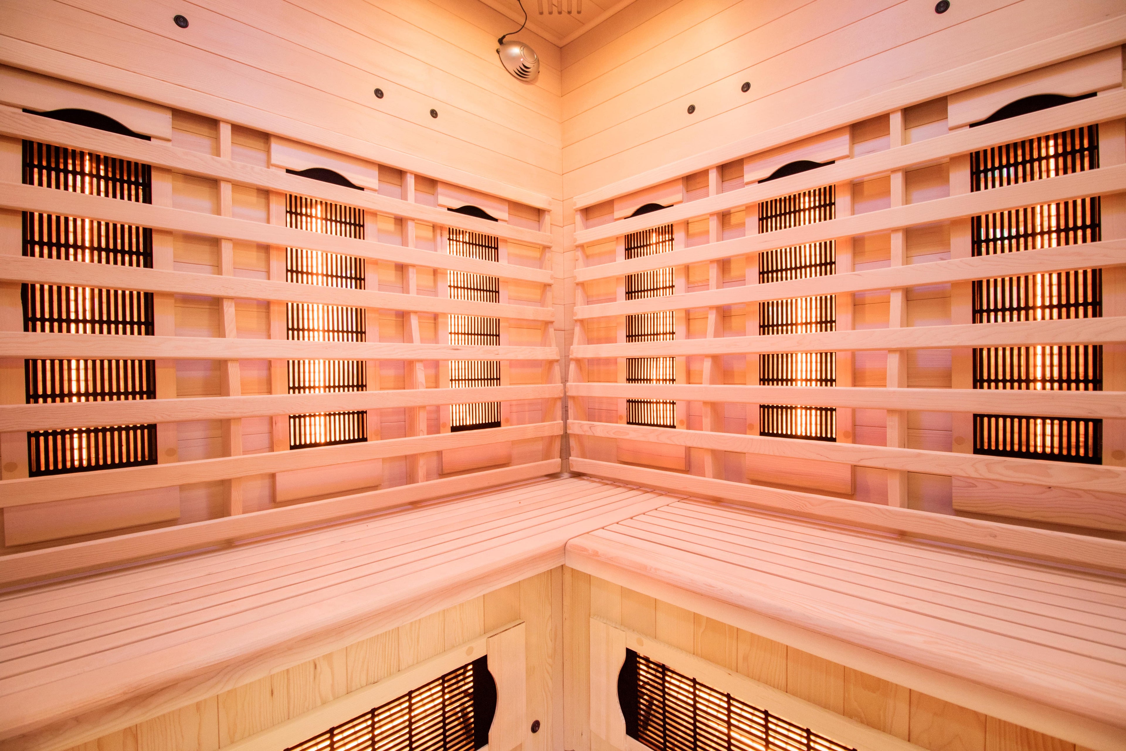 Interior de la sauna Apollon 3C con banco angular en L y emisores Full Spectrum