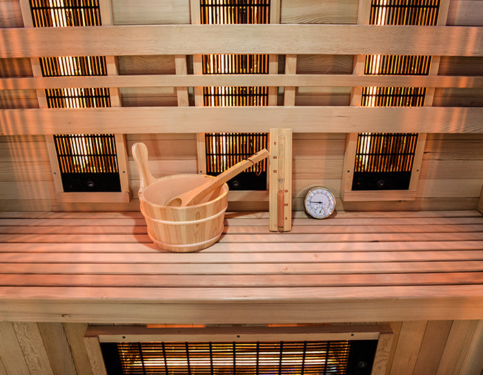 Detalle del banco interior de la Venus Hybrid 2 con cubo, cazo y termómetro de sauna